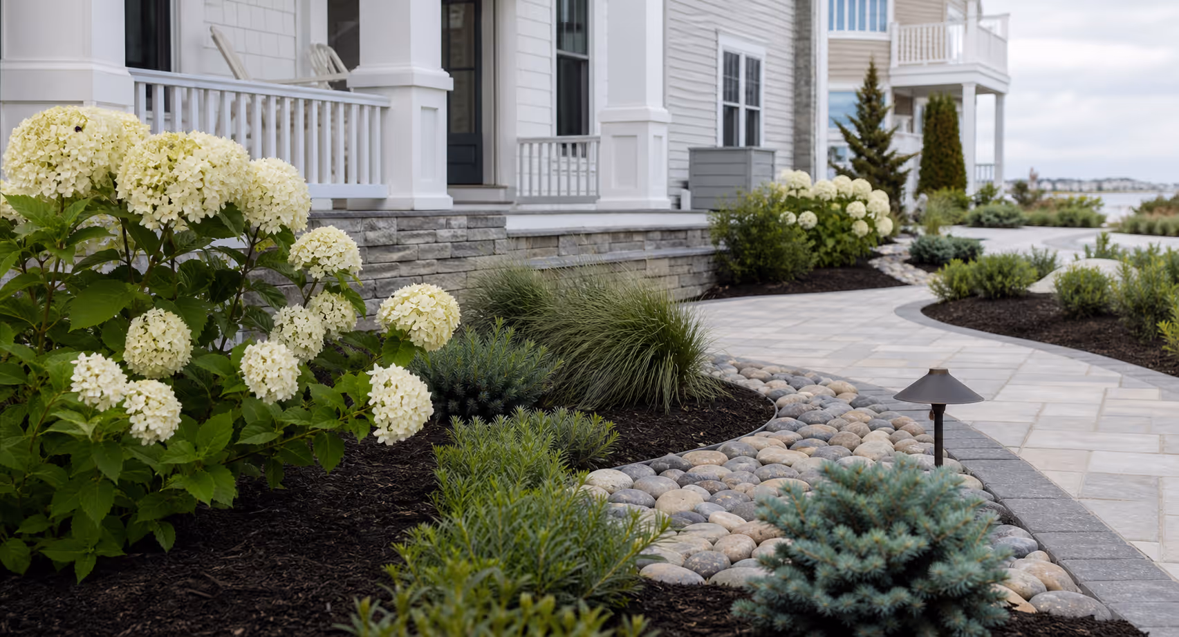 Illustrative shore landscape bed with clean edging and coastal planting
